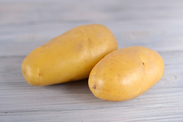 unpeeled fresh potato on wooden gray background