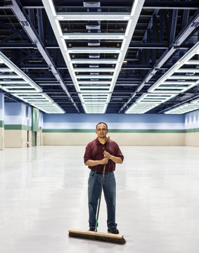Portrait of man standing with broom at convention center