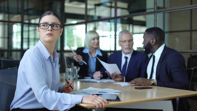 Sad female manager looking window during office meeting, workload tiredness