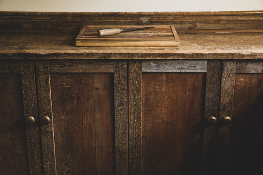 Wooden cutting board and knife on cabinet