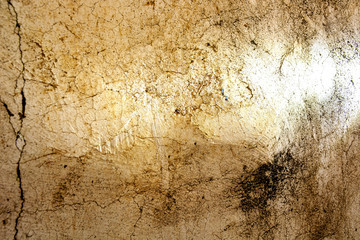 Closeup of an Old Wall with Lots of Cracks, Textures, Shadows and Light. Highly textured exterior wall would make an excellent background or abstract image.