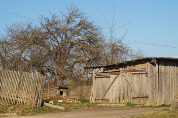 Courtyard of abandoned house with small doghouse in the countryside