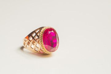 Golden ring with ruby on white background