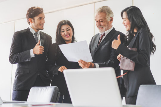 Marketing team consulting sales plan with supervisor senior manager in conference room before presenting to client.