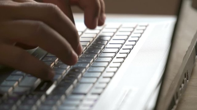 Close-up. The man opens the laptop and begins to press his fingers on the keyboard. Then he closes the laptop. Hands on the keyboard.