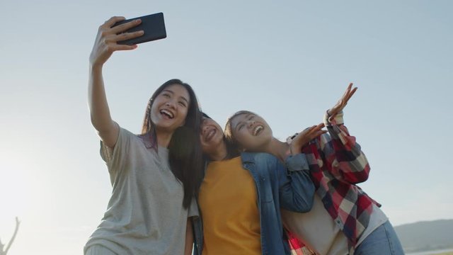 Asian teenager group Are taking pictures and smiling outdoor on summer time