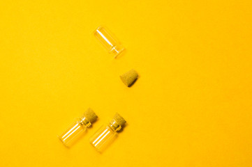 Empty little bottles with cork stopper isolated on yellow. transparent containers. test tubes. copy space