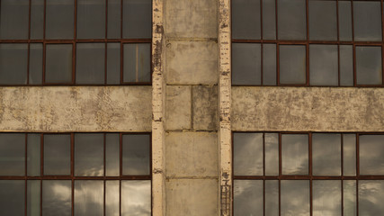 Large windows of the factory on the cement wall