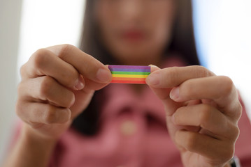 Young woman shows LGBT flag in her hands.