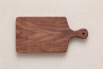 Walnut handmade wood cutting board on the linen	