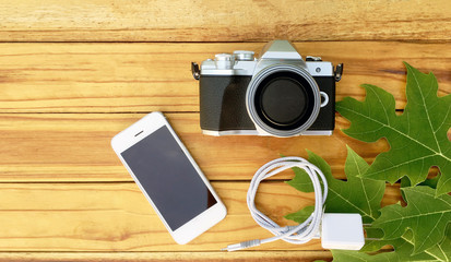 14 July 2019 at Samut Sakhon Thailand people prepare Smartphone and Camera Olympus on wood table vintage before use take photo - Powered by Adobe