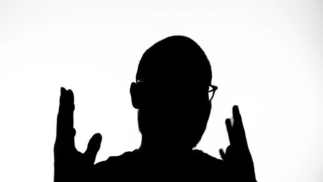 Silhouette of a man explaining something making gestures