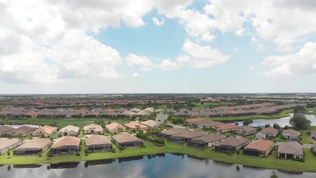 Rising aerial of the South Florida Gulf coast expanse of new homes in a country club community.