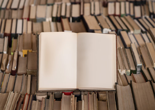 Cloce up view of an opened book over lot of books. Wisdom concept