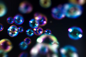 abstract colorful soap bubbles floating on the dark