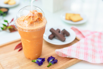 Milk tea or Thai milk tea on the wooden plate.