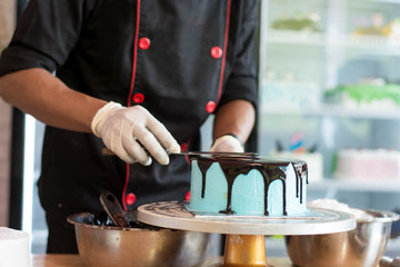 hand of chef decorating cake