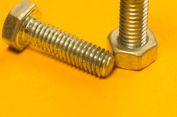 Steel screw on a yellow background