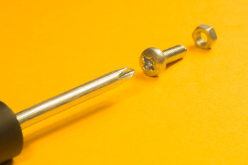 Steel screw on a yellow background