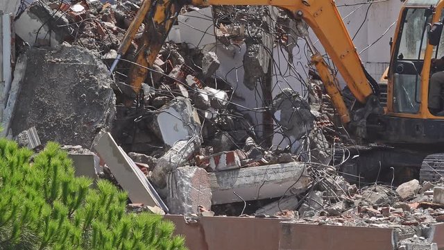 Building Demolition is a stock video that shows fine footage of Building demolition procedure, high reach excavator eliminating old construction. 