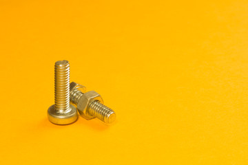 Steel screw on a yellow background