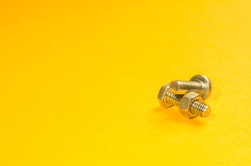 Steel screw on a yellow background