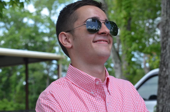 Smug Teenager With Sunglasses In Pink Shirt