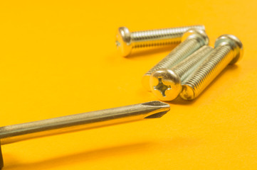 Steel screw on a yellow background