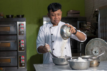 asian chef pouring flour