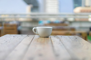 Coffee cup at the end of a wooden table