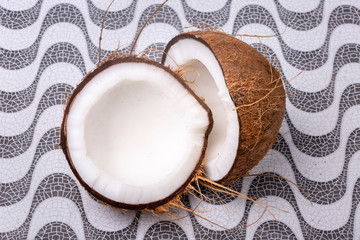 Close up of two coconut halves tightly together with the outer brown shell and inner white coco on...