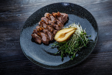 tasty roasted beef meat slices with half of baked pear