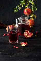 Pomegranates and pomegranate juice on a dark background