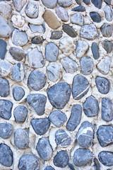 The texture of sea pebbles in cement closeup.