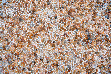 The texture of sea pebbles in cement closeup.