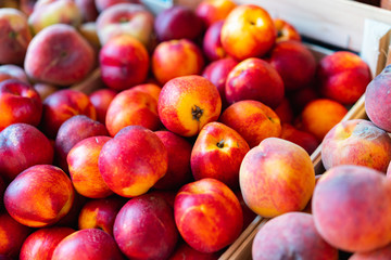 Various apples and peaches for sale at a market