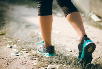 Runner feet running on road closeup on shoe. woman fitness jog workout concept