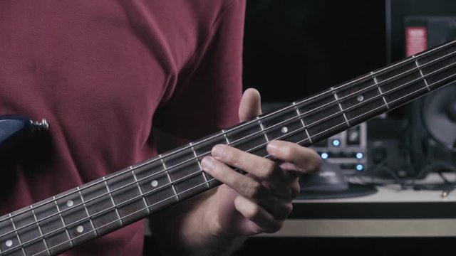 Musician plays bass guitar, close up on the bass neck 4K