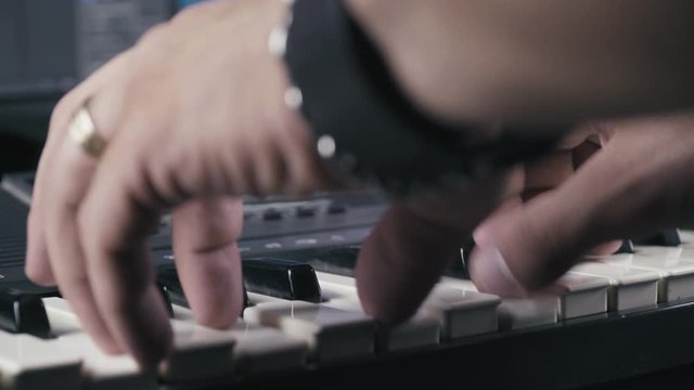 Musician's hands while plays keyboards, close up 4K.
