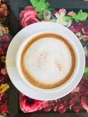 Cap cappuccino coffee over glass on table.