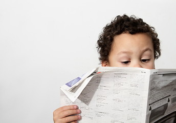 Little boy reading newspaper and smiling in the morning been educated with white background stock...