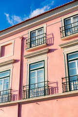Fototapeta na wymiar Pink house with windows and balconies
