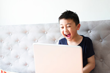 Little boy using laptop play game at home for relax