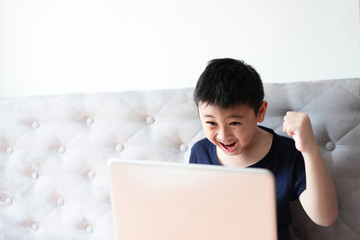 Little boy using laptop play game at home for relax