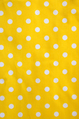 Yellow tablecloth with white dots background texture.