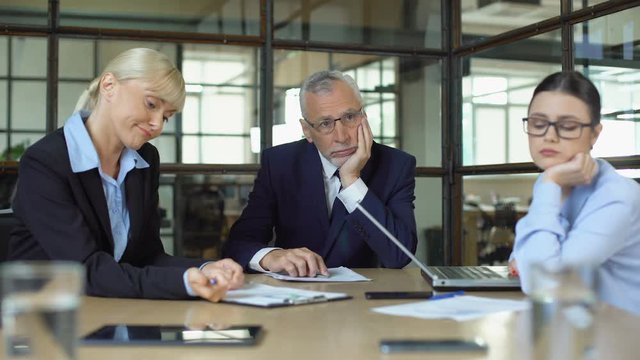 Pensive bored office employees sitting table, lack of ideas occupational burnout