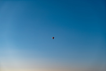 Hot air balloon high in the bright blue sky