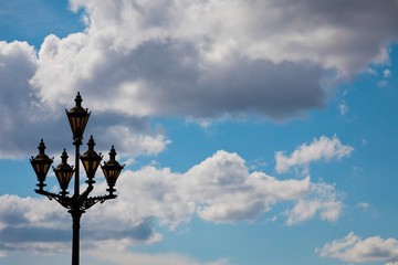 Fototapeta na wymiar Vintage street lamp against blue sky with clouds.