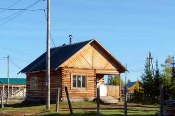 Fototapeta na wymiar New wooden house stands in the village near the forest in Yakutia.
