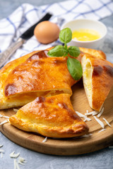 Cut closed pie with cheese and egg (khachapuri).